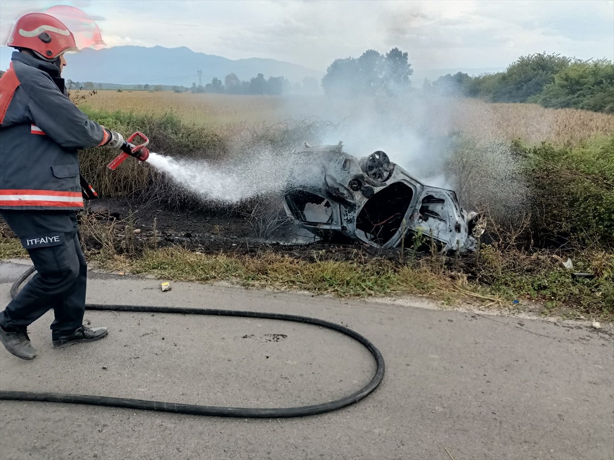 Sakarya'nın Akyazı ilçesinde yol kenarındaki otluk alana devrilen otomobil yanarak kullanılamaz...